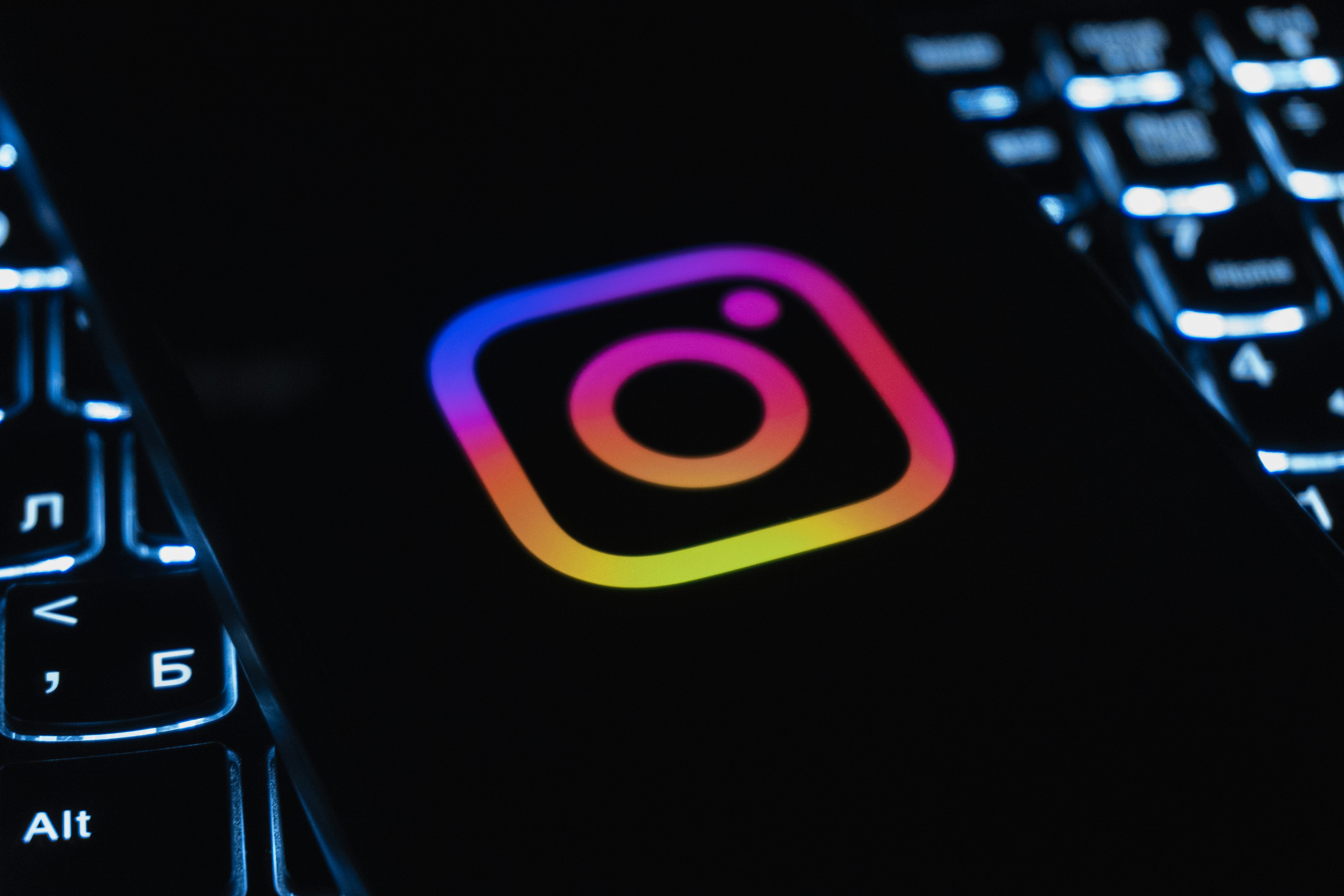 Instagram logo on a dark background with keyboard lights